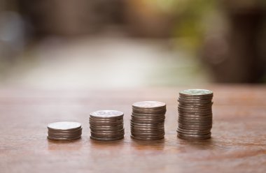 Finans ve para kavramı, para sikke yığını büyüyen grafik üzerinde ahşap ve arka plan bulanık