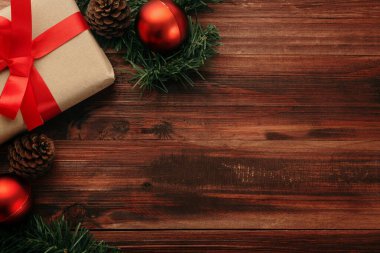 Noel ve yeni yıl hediye kutuları, kırmızı toplar ve ahşap masa arkaplan görünümlü çam kozalağı süslemesi ile fotokopi alanı.