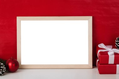 Boş ahşap fotoğraf çerçevesi şablonu ve kırmızı kara zeminde noel süslemesi.