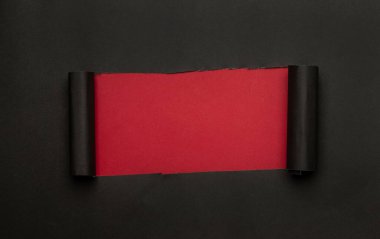 Kırmızı arka planda siyah yırtık bir kağıt. Kara Cuma kampanyası.