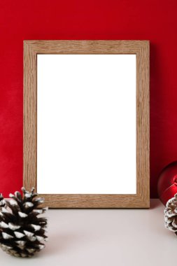 Boş ahşap fotoğraf çerçevesi şablonu ve kırmızı kara zeminde noel süslemesi.