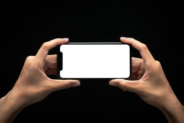 Erkek eller, siyah arka plan, aşırı çalışma ve geç çalışma konsepti, kırpma yolu üzerinde boş ekranlı akıllı telefonu tutuyor..