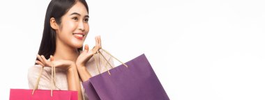 Heyecanlı, güzel Asyalı bir kadının portresi elbise giymiş ve elinde beyaz afişlerde izole edilmiş alışveriş torbaları tutuyordu..