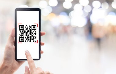 El, alışveriş merkezinin arka planında akıllı telefon taraması QR kodu kullanıyor. Barkod okuyucu, Qr kod ödemesi, Nakitsiz teknoloji, Dijital para kavramı.