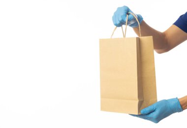 Kapanış teslimatçısı, elinde eldivenlerle beyaz arka planda izole edilmiş kağıt çanta, paketleme modeli, teslimat servisi konsepti var..