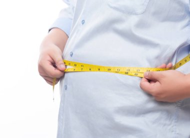 Şişman adam, beyaz arka planda izole edilmiş vücudunu kontrol etmek için bir mezura tutuyor..