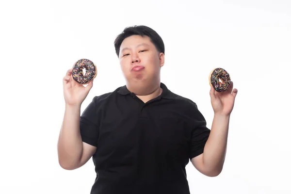 若いです面白い脂肪アジアの男再生とともにチョコレートドーナツ隔離された白い背景 不健康な概念 — ストック写真