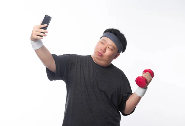 아시아인 재미있는 선수가 덤벨을 가지고 운동을 스마트폰을 사용하면 배경에 셀카를 — 스톡 사진
