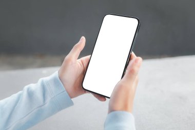 Parkta kırpma yolu olan akıllı telefon boş ekran kullanan bir kadın..