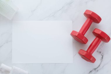 Boş beyaz kağıt not ve beyaz mermer arka planda dambıllar. Sport flat lay, sağlıklı yaşam tarzı ve diyet konsepti.