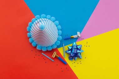 Mutlu yıllar sana. Pastel sarısı, mavi, turuncu ve pembe geometrik arka plan üzerine renkli parti dekorasyonu..