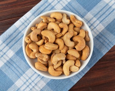 Masanın üzerinde beyaz kasede fındık, düz uzanmış, sağlıklı atıştırmalık, vejetaryen yemeği..