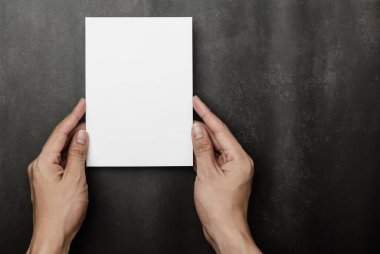 El ele tutuşan davetiye maketi, boş tebrik kartı şablonu. Minimalist tarzda düz yatıyordu..