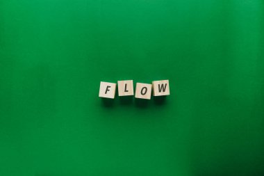 Yeşil arkaplandaki yüksek açılı tahta bloklar. Bu kavram çalışma sürecini, iş sürekliliğini ve odaklanmanın zihinsel durumunu, düzgün işlemleri ve verimliliği temsil eden görselleştirir..