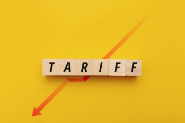 Tahta bloklar TARIFF 'i sarı zemin üzerinde kırmızı aşağı doğru okla heceliyor. Küresel ticaretteki ekonomik gerileme, ticaret engelleri, mali kriz ve olumsuz pazar eğilimlerini temsil ediyor.