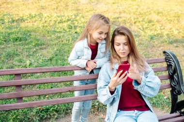7 yaşındaki genç bir anne ve kızı parkta yürürken çevrimiçi bir bağlantıdan bahsediyorlar.
