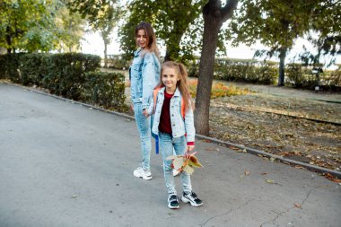 Genç ve güzel bir anne 7 yaşındaki bir kızı okula götürüyor. Liseli kız okula gitmek istemiyor.