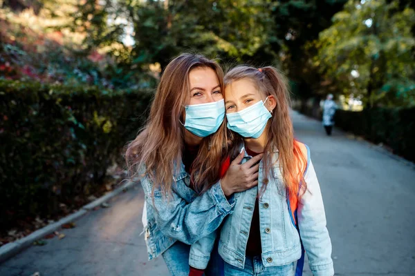 Okula dönelim. Sonbaharda, 7 yaşında bir kız, ailenin genç annesiyle birlikte okula yüz maskesi takarak gider..