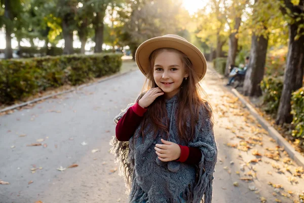 行动自由 7岁的小女孩披着温暖的斗篷和帽子 在公园的小巷里跳舞 — 图库照片