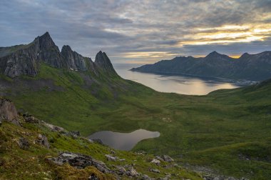 Kuzey Norveç 'te Senja adası üzerinde gün batımı, çerçevenin ortasında Hesten Dağı. (yüksek ISO resmi)