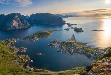Norveç 'in Lofoten şehrinde gündoğumunda Reine kasabasının havadan görünüşü ve arka plandaki dağlar. Yukarıdan yakalanmış.