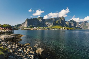 Reine balıkçı köyünde güzel, renkli, aydınlık bir gün ve Lofoten takımadalarında arka planda dağlar, Norveç. 