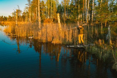 Erkek kâşif gün batımında kuşları izliyor..