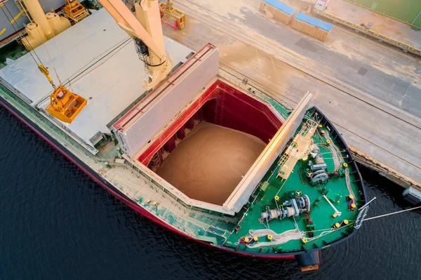 Large international transportation vessel in the port, loading for export in the sea waters.