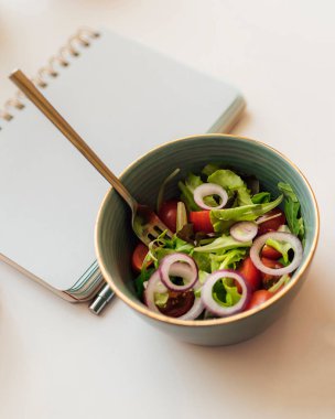 Öğle arasında ofiste salatalı seramik kase. 