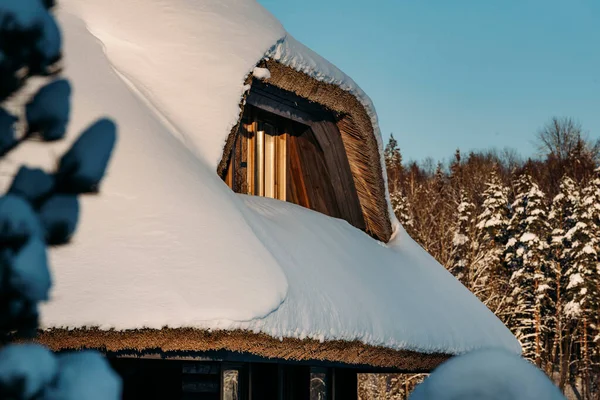 Details of a wooden house in deep winter snow