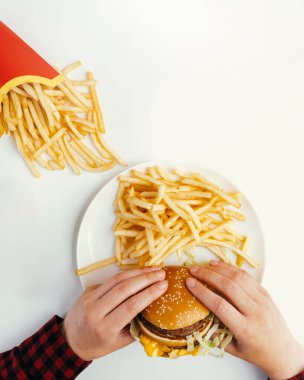 Beyaz masada patates kızartmasının yanında el ele tutuşmak.