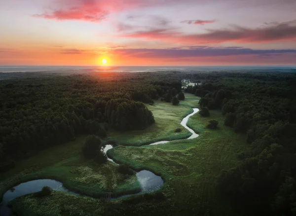 Güneş doğarken Soomaa Ulusal Parkı ve kuş bakışı manzaralı küçük kıvrımlı nehir..