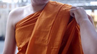 Bir adamın yavaş hareket etmesi Tayland 'da Theravada' da Budizm 'de yeni bir keşiş atamasına neden oluyor. Kıyafetlerini değiştiriyor. Özellikle Budist keşiş cüppesiyle kaplanıyor..