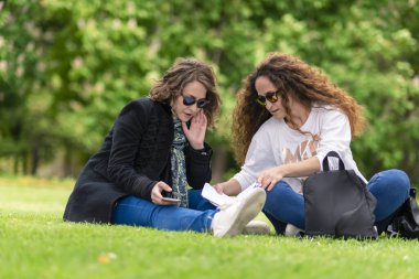 Telefonla konuşuyor, çalışıyor, parkta dinleniyor, çimlerin üzerinde oturuyor..