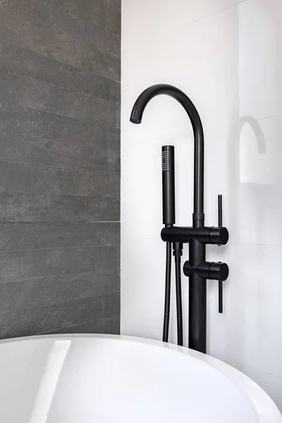 Nuevo grifo negro y cabezal de ducha contra la pared blanca y gris de azulejos limpios del cuarto de baño en apartamento moderno. —  Fotos de Stock
