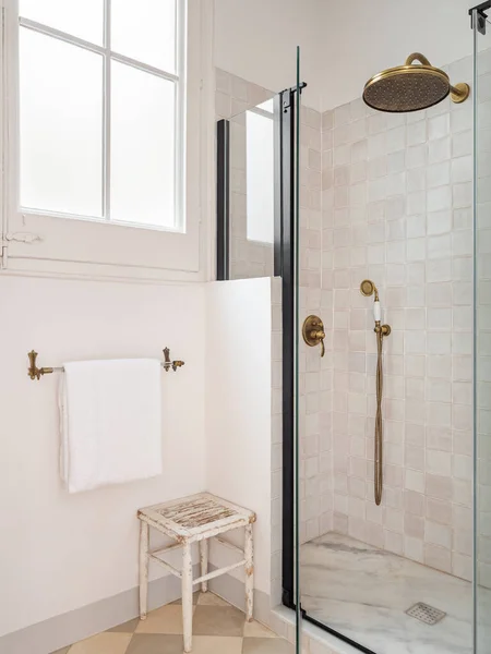 Vintage bézs színű fürdőszoba zuhanyzóval zóna, ablak, törölköző és fa széklet — Stock Fotó