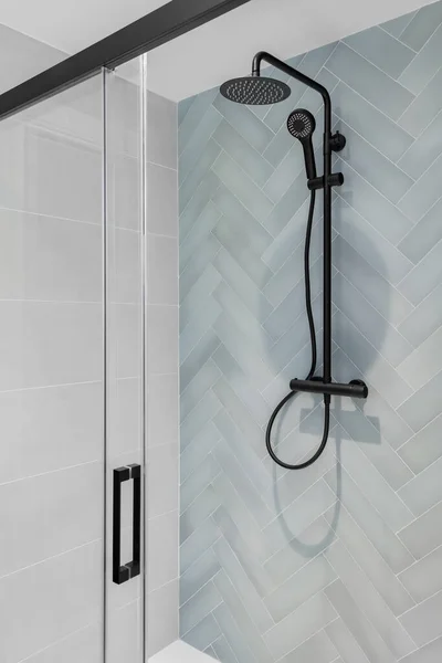 Zona de ducha moderna con cabeza de lluvia, ducha de mano y puerta de cristal. Azulejos azul claro y blanco en el baño —  Fotos de Stock