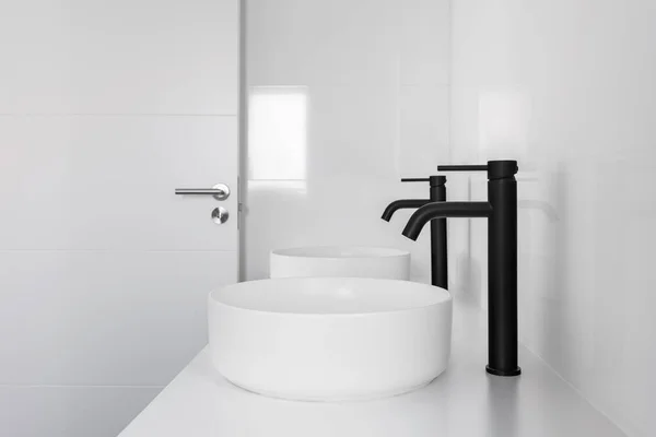 Baño de azulejos blancos con dos lavabos y grifos negros —  Fotos de Stock