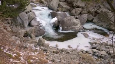 Güzel küçük şelale. Nehir, dağ geçidi boyunca biriken karlar boyunca akar..