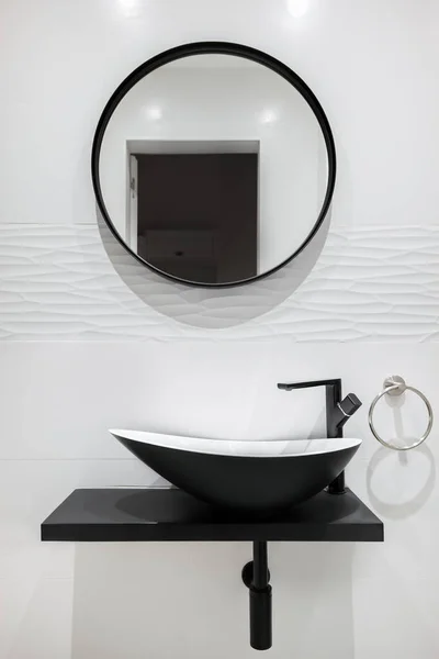Λευκό πλακάκι μπάνιο με μαύρη βρύση και λεκάνη και στρογγυλό καθρέφτη. Μοντέρνο και μινιμαλιστικό στυλ. — Φωτογραφία Αρχείου