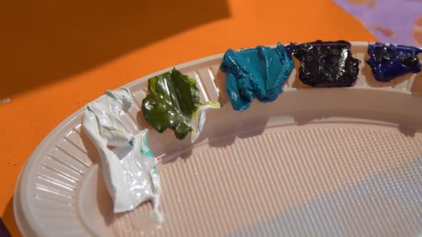 Разноцветные масляные краски на белой пластиковой пластине. Домашняя мастерская, рукоделие, концепция hand-made. — стоковое видео