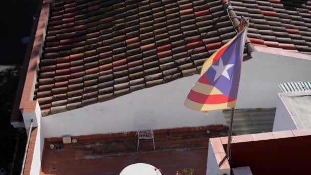Döşeme çatısının arka planında rüzgarda dalgalanan Katalan bayrağı. Yavaş çekim. — Stok video