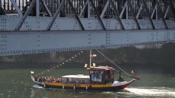 Туристичний рабело човен проходить через річку під мостом Понте-Луїс на річці Доро, Порту. — стокове відео