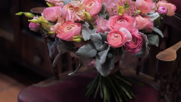 Hermoso ramo de rosas rosadas y amarillas recién cortadas en la silla vintage en la tienda de flores. — Vídeo de stock