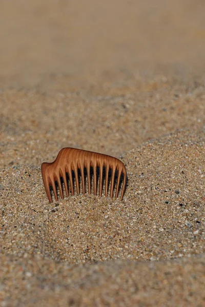 Pente de madeira artesanal de árvore de pêra para massagem no couro cabeludo e pentear o aroma na praia na areia. — Fotografia de Stock