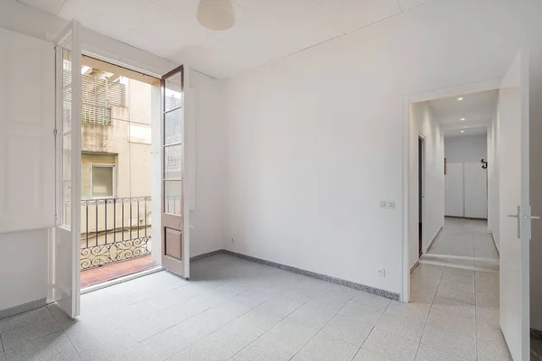 Quarto branco vazio com corredor que leva a outros quartos e pequena varanda. Apartamento típico no Bairro Gótico, zona antiga de Barcelona. — Fotografia de Stock