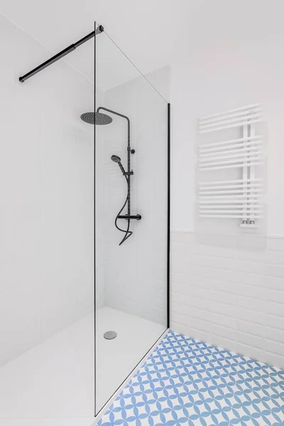 Μπάνιο διακοσμημένο με γαλάζια και λευκά πλακάκια. Σύγχρονη ζώνη ντους με μεγάλο κεφάλι βροχής, χειρός ντους και γυάλινη πόρτα. — Φωτογραφία Αρχείου