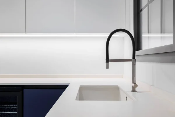 Schwarzer Wasserhahn mit weißer Spüle in einer stilvollen modernen Küche. Minimalismus in sanierter Wohnung. — Stockfoto