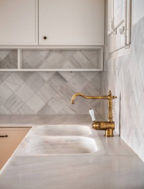 Bronz antika musluk boş mutfak içinde kırsal alanda hafif mobilyalar ve mermer kaplama duvarlı retro tarzı. Seçici odak.