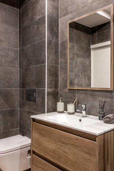 Modern renoviertes Badezimmer mit Toilette. Holzfuß mit weißem Waschbecken und Spiegel. — Stockfoto